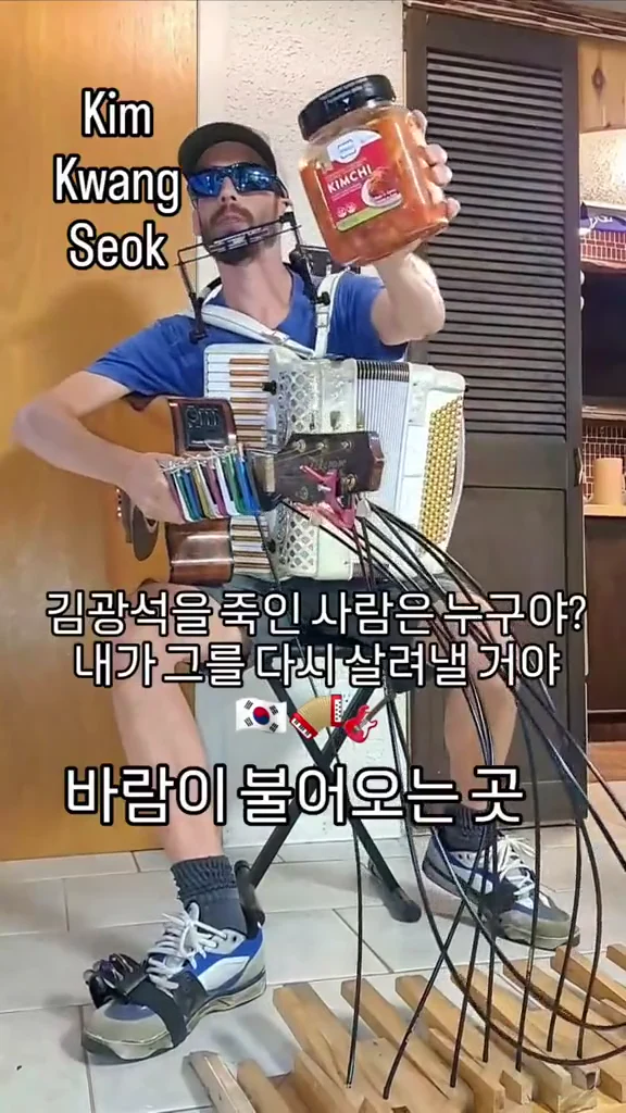 선글라스를 쓴 연주자가 아코디언과 하모니카로 연주하고 있는 세로 영상